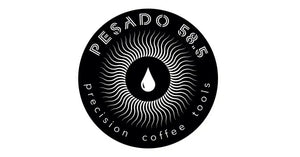 Black circular logo featuring a coffee drop surrounded by radiating lines and text reading ’PESADO 58.5 precision coffee tools’