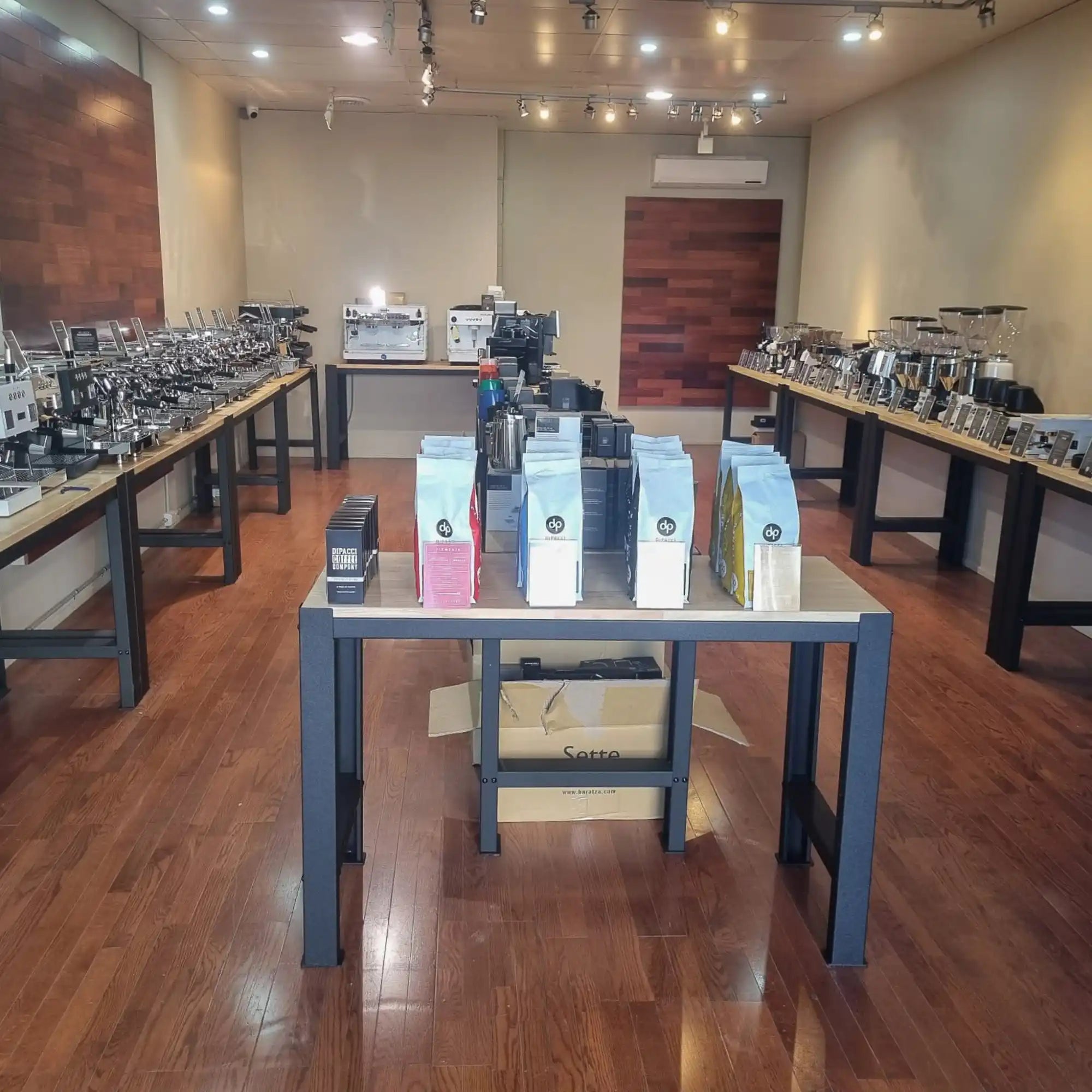 Coffee brewing equipment and bags of coffee beans displayed on tables.